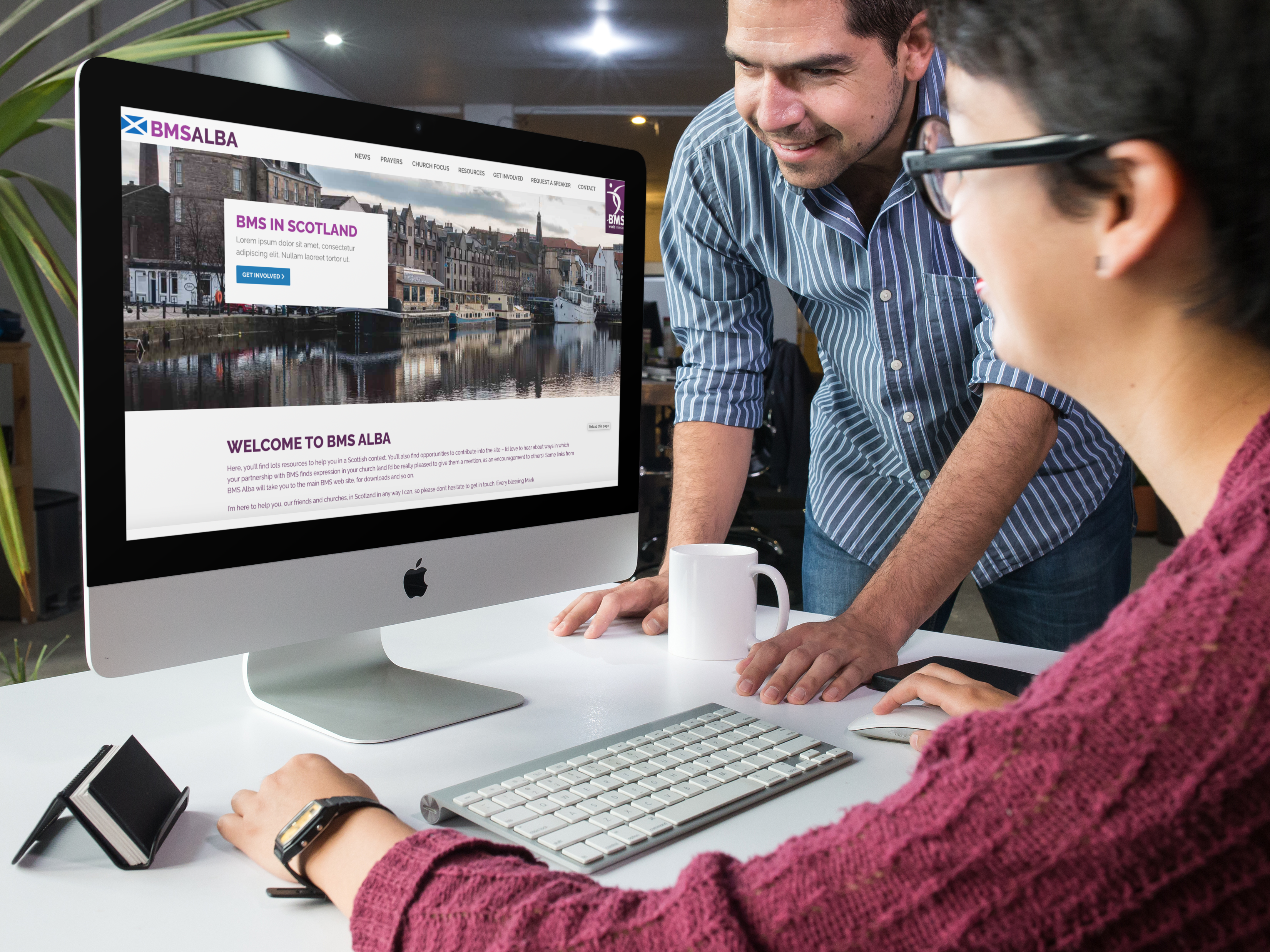 Two people looking at a charity website on a computer screen