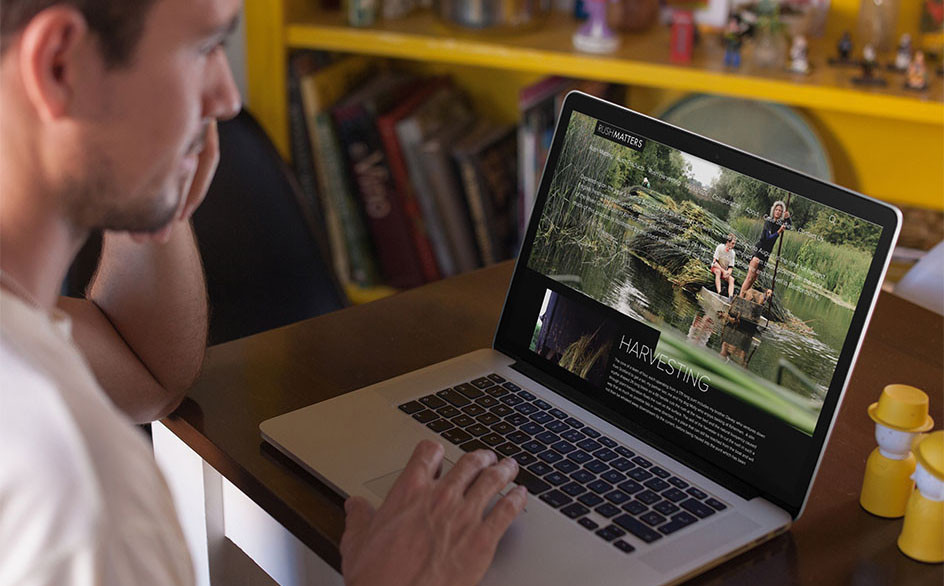 Main in white t-tshirt looking at his macbook (laptop). He is looking a the Rush Matters website.